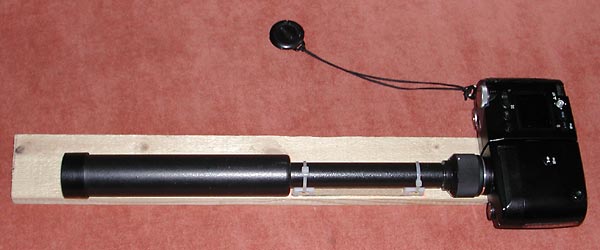 A camera
      and small telescope are fixed to a wood bar
