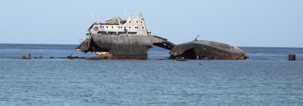 Lullia, rusting ship, washed up on a coral reef