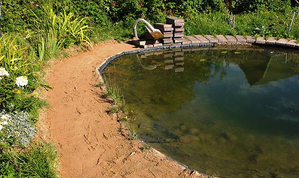 Выравниваем
      песок вдоль берега пруда